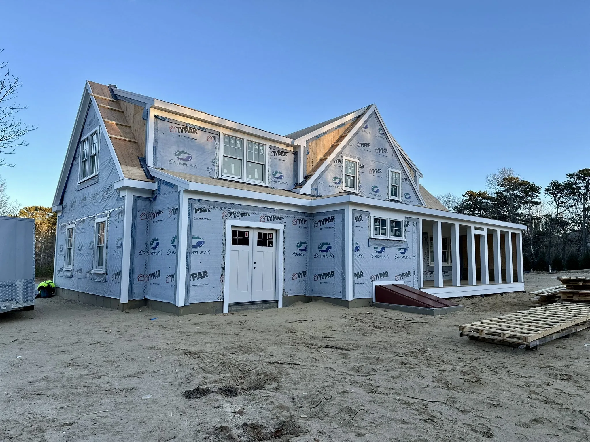 Side view of the house in progress with porch and framing